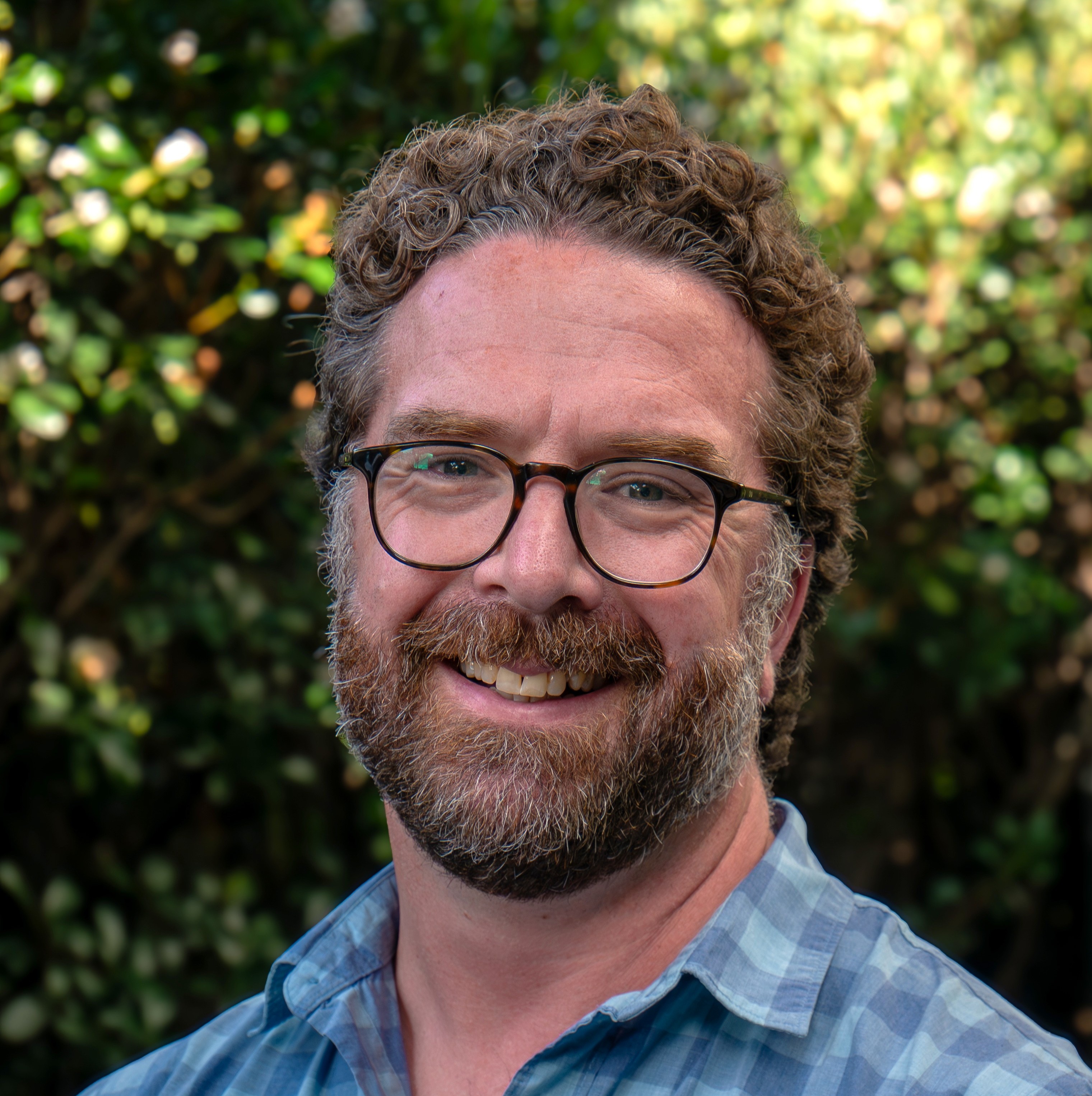 Josh smiling with glasses and a blue shirt